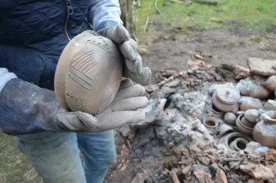 Pot being removed from the recreated anglo saxon kiln after firing